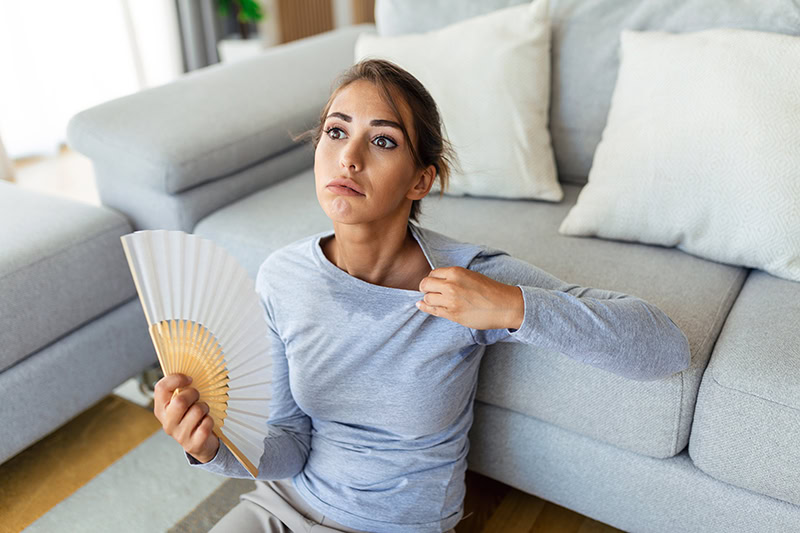 Woman fanning herself trying to cool off.