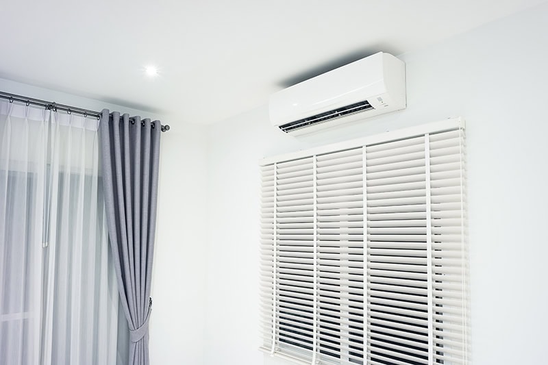 Photo of a living room with an AC unit installed on the wall.