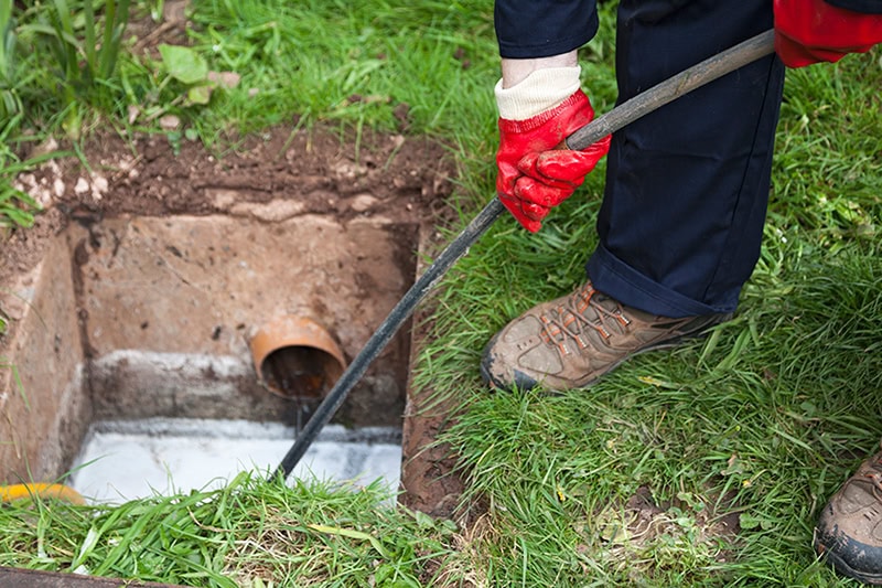 Common Sewer Odors in Your Home: What’s That Smell? A plumber cleaning a sewer line.